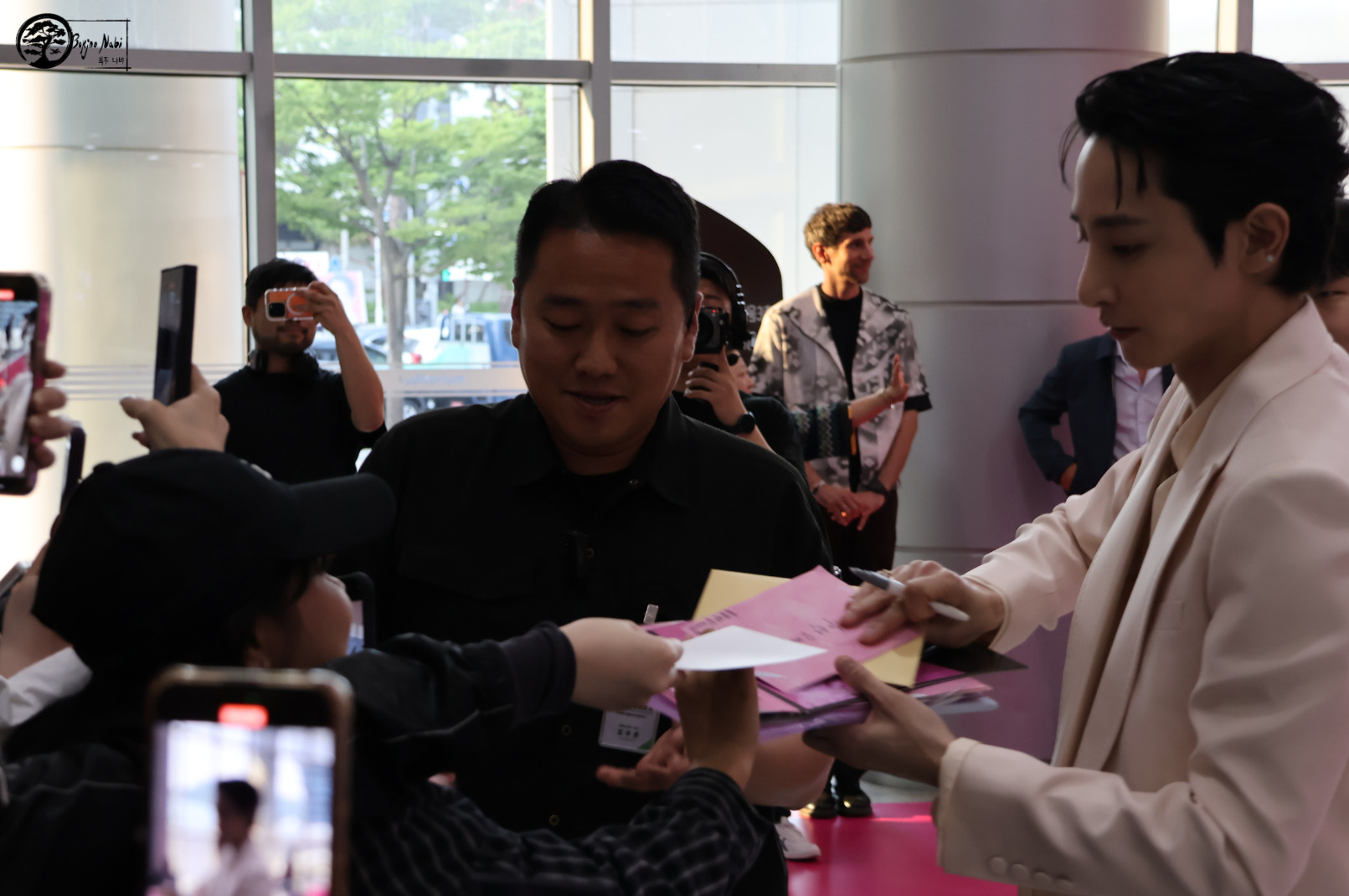 Lee Soo-Hyuk prenant le temps de signer des autographes et recevoir des cadeaux, lors de sa venue sur le tapis rose de Canneseries à Busan. Photo par Marion Pichardie
